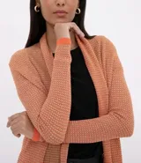 Cardigan largo de tricot color salmón con hilo metálico, terminaciones y puños en color naranja contrastante.