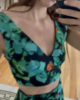 Top corto con estampado floral en tonos verde, azul y naranja, con escote en V.
