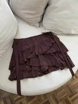 Minifalda marrón con volados y lazos laterales.