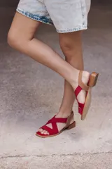 Sandalia roja con tiras cruzadas de neopreno, plantilla de cuero y taco bajo de madera.