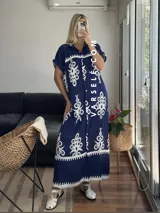 Vestido camisero largo negro con estampado de flores blancas y cinto incluido.