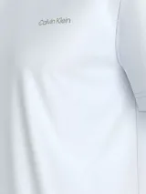 Remera blanca de algodón regenerativo, corte regular fit, cuello redondo y mangas cortas. Presenta el logo de Calvin Klein en el pecho y un logo más grande en la espalda.
