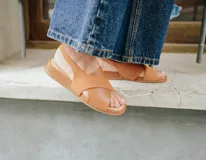 Sandalias color caramelo con tiras cruzadas, talón con elástico interno y plantilla de cuero acolchada.