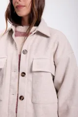 Sobrecamisa beige de paño con cuello clásico, cierre frontal con botones a tono, dos bolsillos de parche en el pecho y corte holgado.