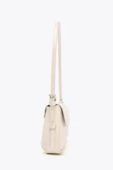 Bolso de hombro color crema con efecto acharolado, solapa con cierre magnético y asa ajustable.