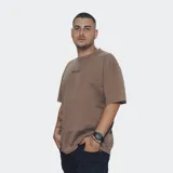Remera de algodón color marrón con efecto gastado o acid wash, corte oversize y cuello redondo. Presenta un pequeño estampado en el pecho con la palabra "RELAJO".