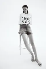 Short de denim de algodón levemente elástico con bolsillos parche delanteros y traseros. Modelo de tiro alto con cierre y botón.