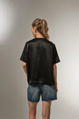 Blusa negra de poliéster con cuello redondo y corte ancho.