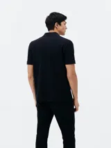 Camiseta tipo polo de manga corta, color azul oscuro, con cuello y tapeta de dos botones.