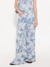 Pantalón de jean de corte wide con cinco bolsillos, estampado tie-dye celeste y blanco.