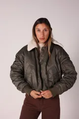 Campera bomber verde militar con cuello de corderito desmontable y cierre frontal.