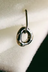 Aros colgantes con forma de dona color negro con detalles dorados.