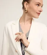 Blazer negro de punto roma con cuello solapa, cierre con ganchos, botones delanteros y forro de poliéster.