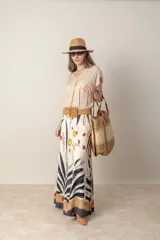 Pantalón palazzo de viscosa color crudo con estampado abstracto en tonos negro, naranja y amarillo. Cintura elastizada en la parte trasera.
