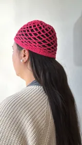Gorro fucsia de tejido crochet calado.