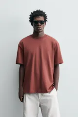 Camiseta blanca de algodón interlock con elasticidad, corte recto, cuello redondo y mangas cortas.