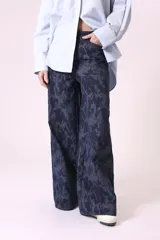 Pantalón de jean de corte ancho con estampado abstracto en tonos azules.