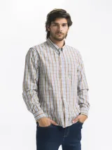 Camisa celeste y blanca a rayas verticales, de manga larga y corte clásico. Tiene cuello abotonado y bolsillo en el pecho.