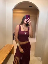 Top corto color borgoña con breteles anchos y detalle de sol dorado en el centro.