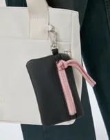 Cartera mini city negra de tela deportiva con pouch con cierre, correa regulable y desmontable, manijas superiores, cierre superior, bolsillo frontal con cierre y doble bolsillo lateral.