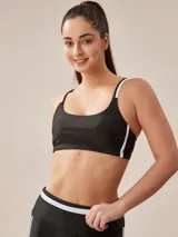 Top deportivo negro con tirantes finos blancos y banda inferior blanca.