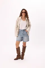 Campera color crema tipo gamuza con cierre frontal, cuello clásico, mangas largas y calados florales en hombros y espalda.