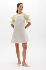 Vestido corto con cuerpo a rayas verticales en tonos beige y blanco, mangas cortas abullonadas y canesú superior en color negro.