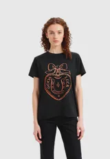 Remera negra de algodón de manga corta, corte al cuerpo y cuello redondo, con estampado frontal de un corazón con un lazo y la leyenda "Good Luck" en color naranja.