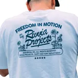 Remera blanca de manga corta con estampa centrada en el pecho con el texto "Rivvia Projects" en azul y cinco estrellas debajo.