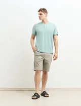 Remera manga corta con cuello redondo y tapeta con dos botones.