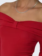 Top rojo con hombros descubiertos, mangas largas y detalle de lazo decorativo.