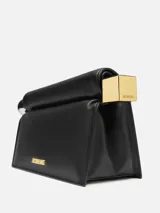 Clutch negro de cuero napa con cierre magnético. Tiene terminaciones metálicas plateadas y doradas, logo dorado y bolsillo interior para tarjetas.