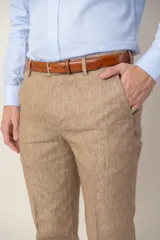 Pantalón de vestir de lino color beige, corte slim fit, con bolsillos laterales y traseros.