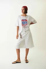 Bermuda blanca de denim, tiro bajo, con cuatro bolsillos, pasacintos, cartera con cierre y botón metálico.