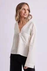 Camisa color crudo con cuello en V y manga larga.