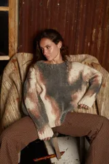 Sweater de lana tejido con cuello redondo y calce holgado, con diseño irregular en tonos gris, beige y marrón.