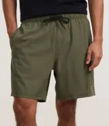 Bermuda de hombre color beige confeccionada en tejido ripstop, con cintura elástica ajustable con cordón, bolsillos laterales y etiqueta de la marca aplicada.