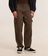 Pantalón baggy color marrón confeccionado en sarga de algodón, con cintura con trabillas, cierre tradicional y bolsillos cargo laterales.