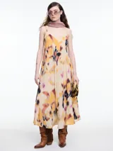 Vestido largo de breteles finos confeccionado en viscosa crinkled con estampa de manchas. De escote en V y silueta evasé, tiene una caída fluida que acompaña el movimiento. El efecto arrugado del tejido le da textura y carácter a una prenda fresca y versátil.
