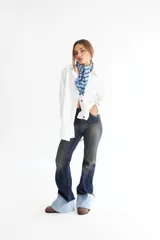 Pantalón jean oxford de tiro alto, color azul oscuro con desgaste en los muslos y rodillas. Presenta alforzas en el delantero y dobladillo en la botamanga.