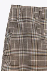 Pantalón de tiro alto con estampado de cuadros en tonos marrones y grises, con bolsillos delanteros y falsos bolsillos traseros. Cierre frontal con cremallera y botón.