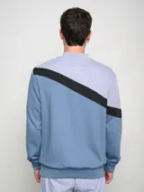 Buzo Umbro a la base con cortes y cambios de color: rojo, gris y negro. Logotipo Umbro estampado en el pecho.