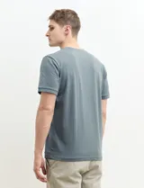 Remera manga corta con cuello redondo y tapeta con dos botones.