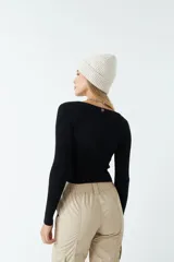 Top rojo de tejido de punto acanalado, con escote en V y mangas largas. Presenta un frunce central con cordón ajustable.