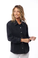 Sobrecamisa de jean color negro con cuello clásico, cierre frontal con botones metálicos, mangas largas con puños abotonados y bolsillos de parche en el pecho.
