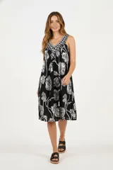 Vestido largo de algodón con estampado de flores blancas sobre fondo negro y cuello en V con detalle bordado.