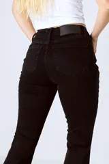 Pantalón de jean negro de corte acampanado y tiro alto.