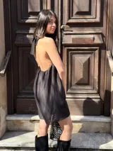 Vestido corto negro con cuello halter y corte holgado.
