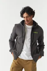 Campera gris de felpa con capucha y cierre frontal. Tiene bolsillos con cierre, lettering estampado en la espalda y logo en grifa de goma.