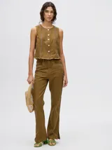 Pantalón de jean azul de tiro alto y corte oxford con apliques metálicos en bolsillos y laterales.